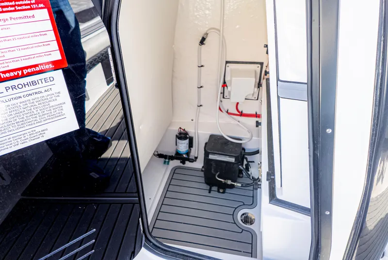 Slide: The Image of 2025 Tidewater 2500 Carolina Bay interior compartment with equipment and warning labels. - 34