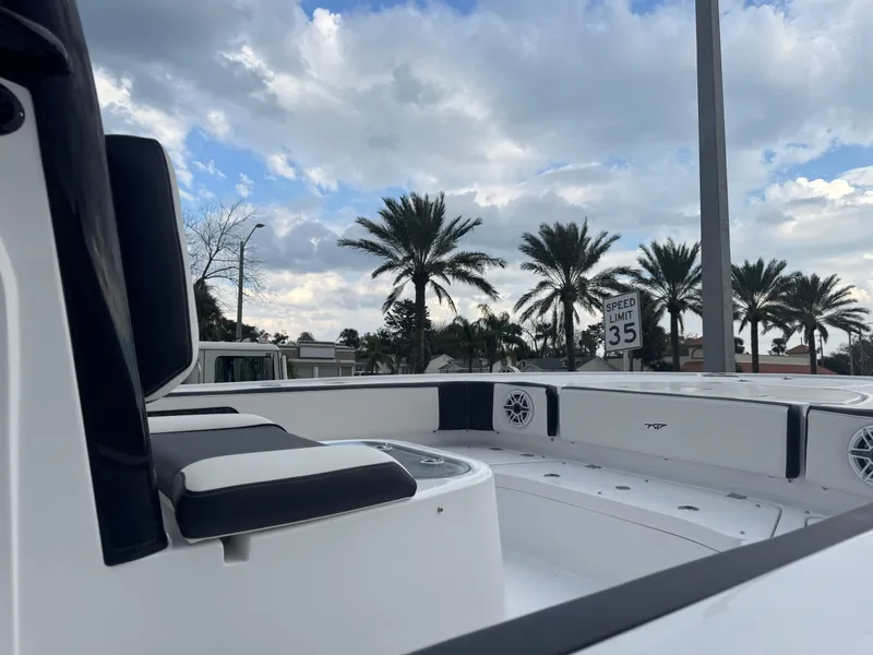 Slide: The Image of 2025 Tidewater 2700 Carolina Bay boat interior with palm trees and cloudy sky. - 12