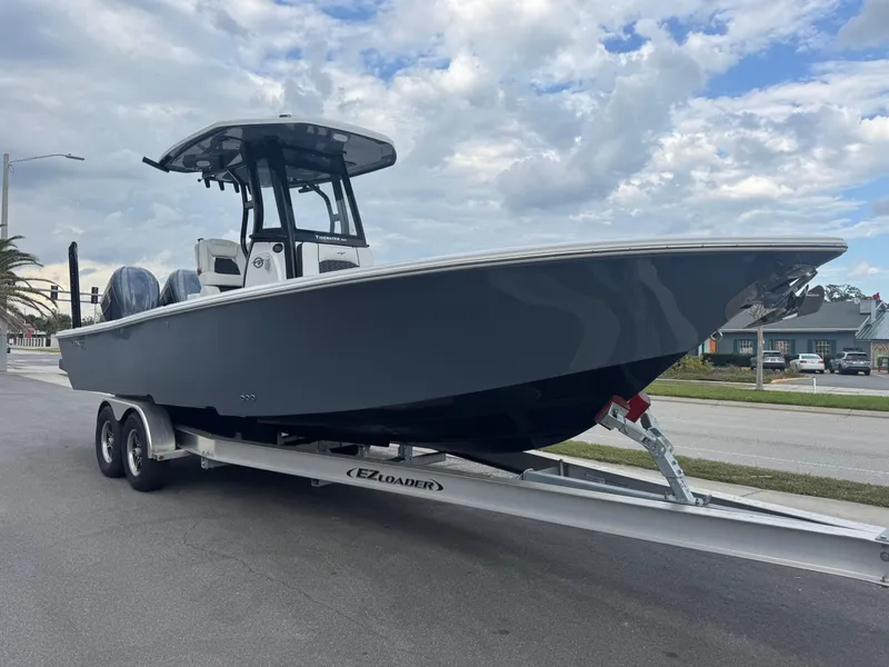 Slide: The Image of 2025 Tidewater 2700 Carolina Bay boat on trailer under cloudy sky. - 4