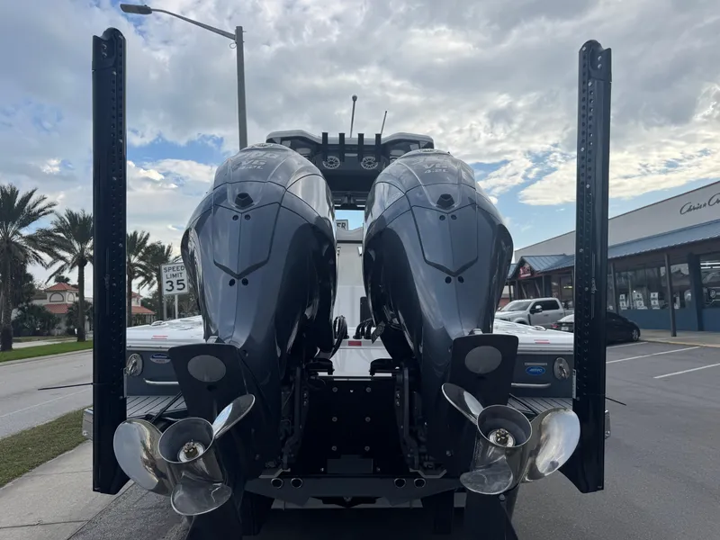Slide: The Image of 2025 Tidewater 2700 Carolina Bay boat with dual outboard motors, parked on a street. - 8