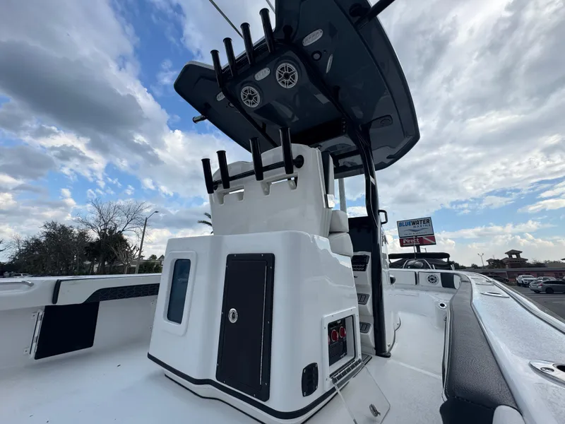 Slide: The Image of 2025 Tidewater 2700 Carolina Bay boat with T-top and rod holders under a cloudy sky. - 9