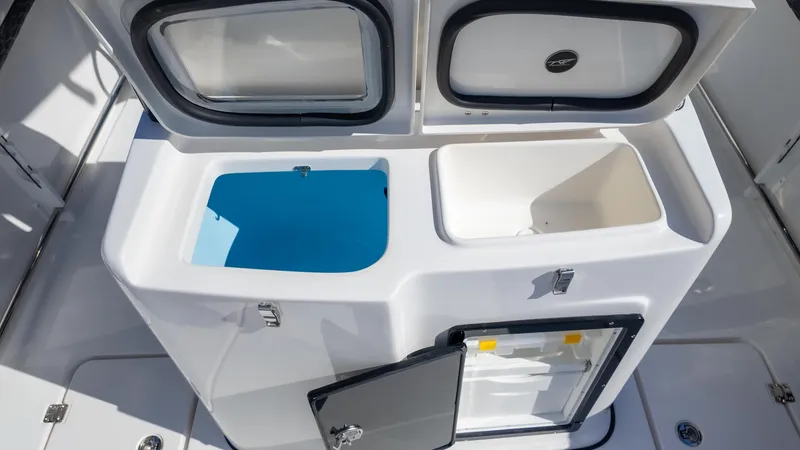 Slide: The Image of 2025 Tidewater 282CC boat storage compartments with open lids, showcasing interior space. - 16