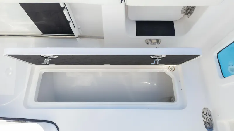 Slide: The Image of 2025 Tidewater 282CC boat storage compartment with open lid, showcasing interior space. - 17