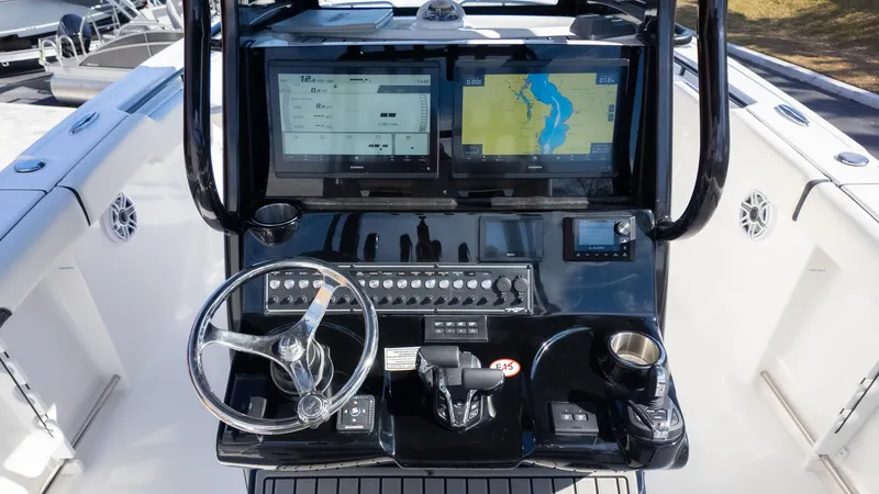 Slide: The Image of 2025 Tidewater 282CC boat dashboard with dual screens and steering wheel. - 20