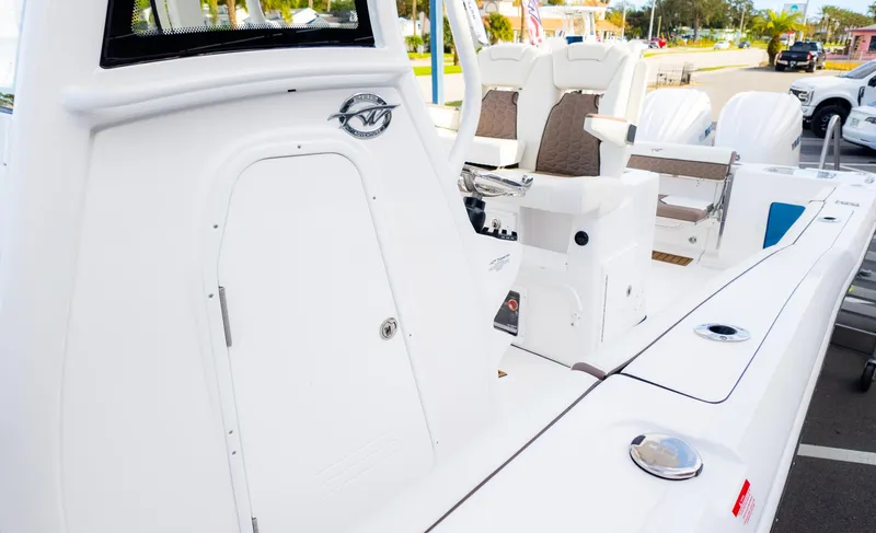 Slide: The Image of 2025 Tidewater 282CC boat interior with seating and control panel, parked outdoors. - 13