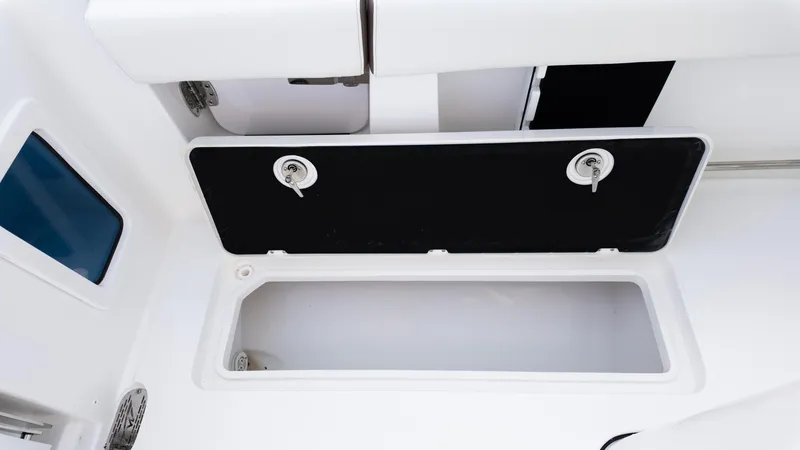 Slide: The Image of 2025 Tidewater 282CC boat storage compartment with open hatch and secure locks. - 16