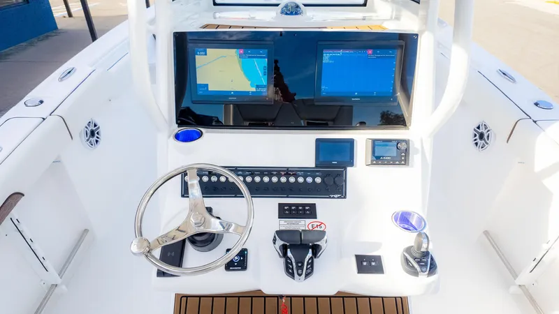 Slide: The Image of 2025 Tidewater 282CC boat dashboard with dual navigation screens and steering wheel. - 18