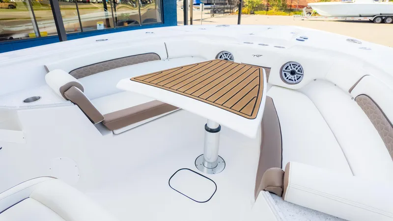 Slide: The Image of 2025 Tidewater 282CC boat interior with cushioned seating and a wooden table. - 25