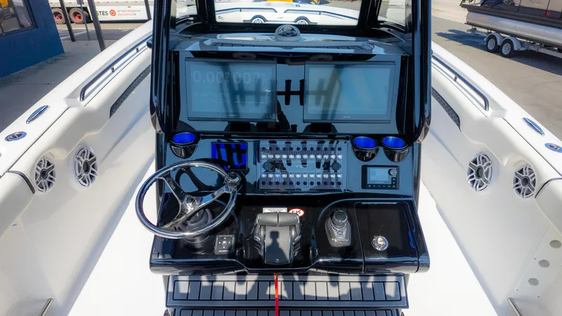 Slide: The Image of 2025 Tidewater 320cc boat dashboard with steering wheel, touchscreen displays, and control panel. - 19