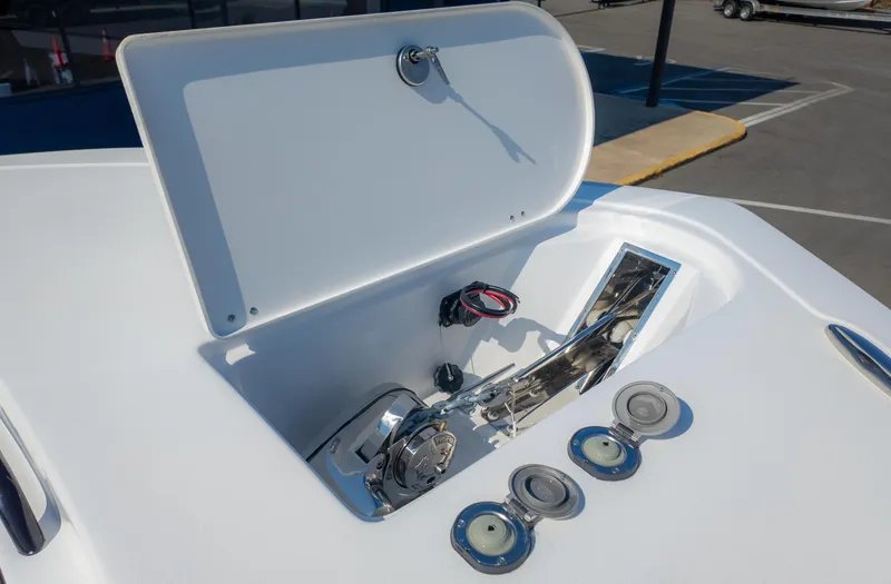 Slide: The Image of Tidewater 320cc 2025 boat anchor compartment with open hatch and cleats. - 24