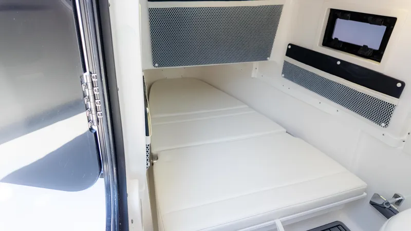 Slide: The Image of 2025 Tidewater 320cc cabin interior with white cushioned seating and storage compartments. - 26
