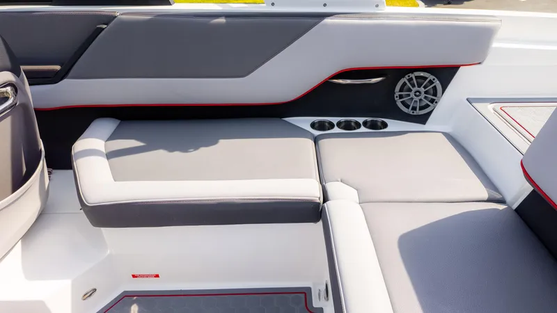 Slide: The Image of 2024 Cobalt CS23 Surf boat interior with gray seating, cup holders, and speaker. - 21
