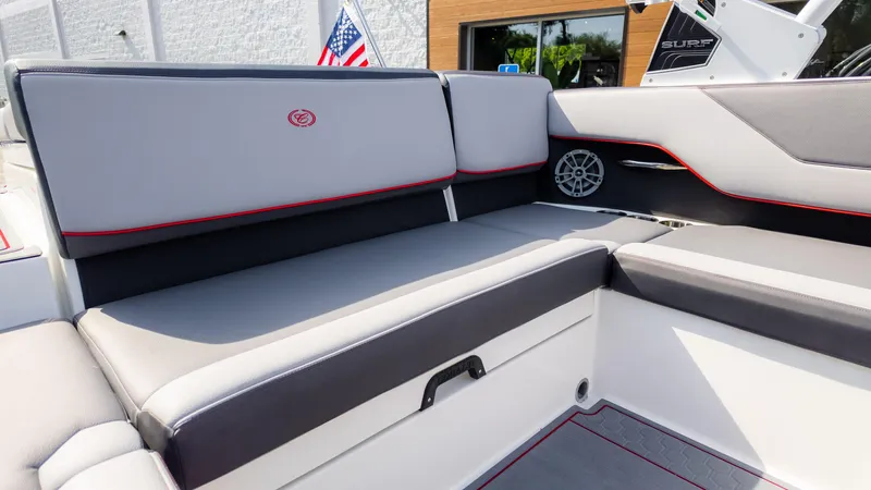 Slide: The Image of 2024 Cobalt CS23 Surf boat interior with gray seating and red accents. - 24
