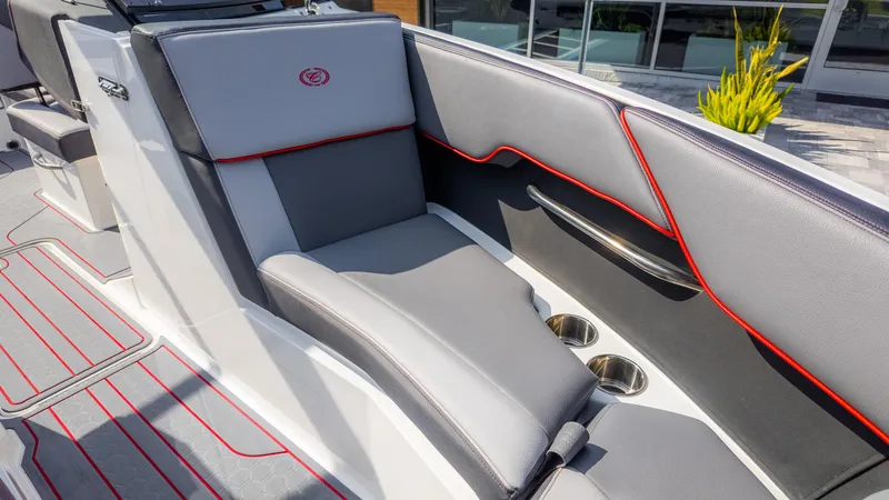Slide: The Image of 2024 Cobalt CS23 Surf boat interior with gray and red seating, cup holders, and modern design. - 32