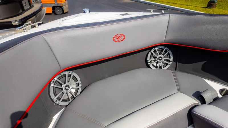 Slide: The Image of 2024 Cobalt CS23 Surf boat interior with gray seating and built-in speakers. - 33