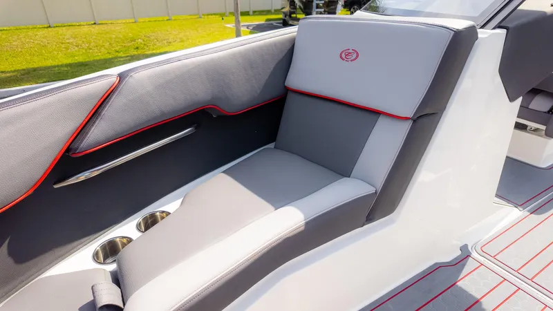 Slide: The Image of 2024 Cobalt CS23 Surf boat interior with gray and red-trimmed seating, cup holders, and sleek design. - 35