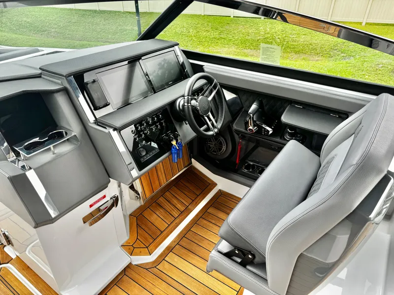 Slide: The Image of 2025 Cobalt R33 boat cockpit with modern controls, dual screens, and luxurious seating. - 16