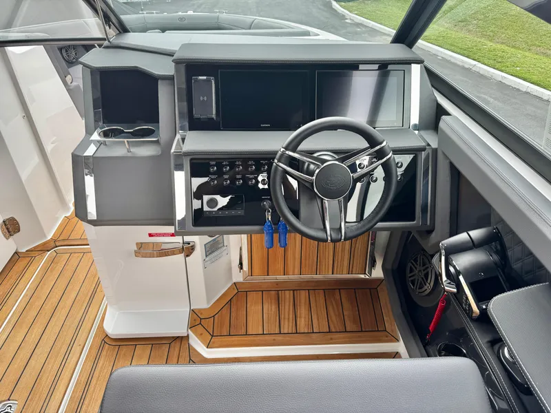 Slide: The Image of 2025 Cobalt R33 boat helm with modern controls and wooden flooring. - 17