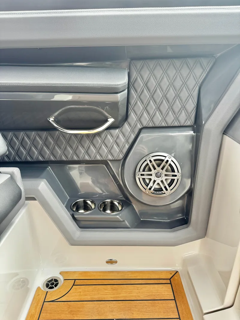 Slide: The Image of Interior detail of 2025 Cobalt R33 boat, featuring speaker, cup holders, and wood flooring. - 20