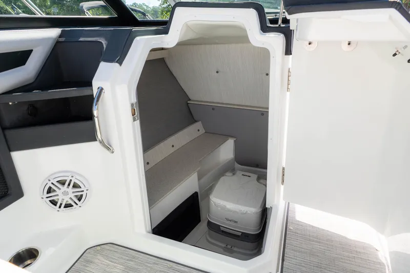 Slide: The Image of 2024 Cobalt R6 OB boat interior with storage compartment and portable toilet. - 36