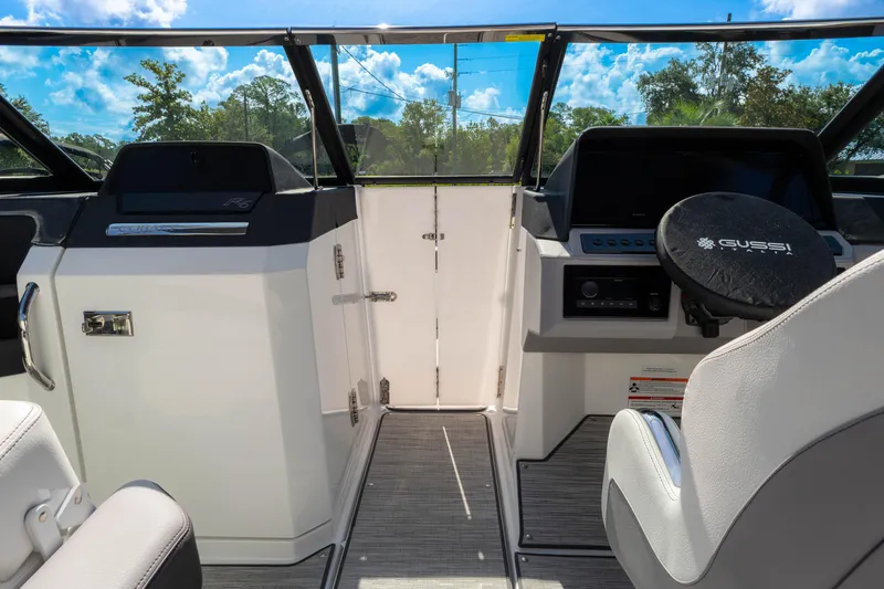 Slide: The Image of 2024 Cobalt R6 OB boat interior with steering wheel and dashboard under blue sky. - 43