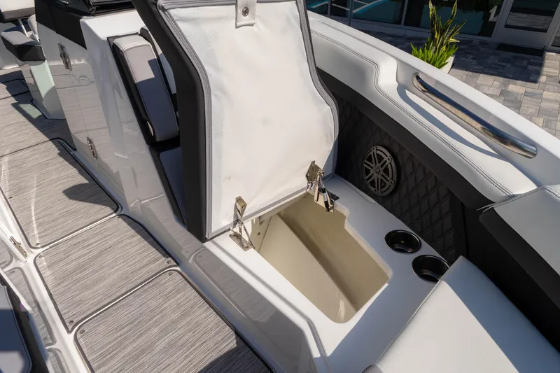 Slide: The Image of 2024 Cobalt R6 OB boat interior with open storage compartment and cup holders. - 46