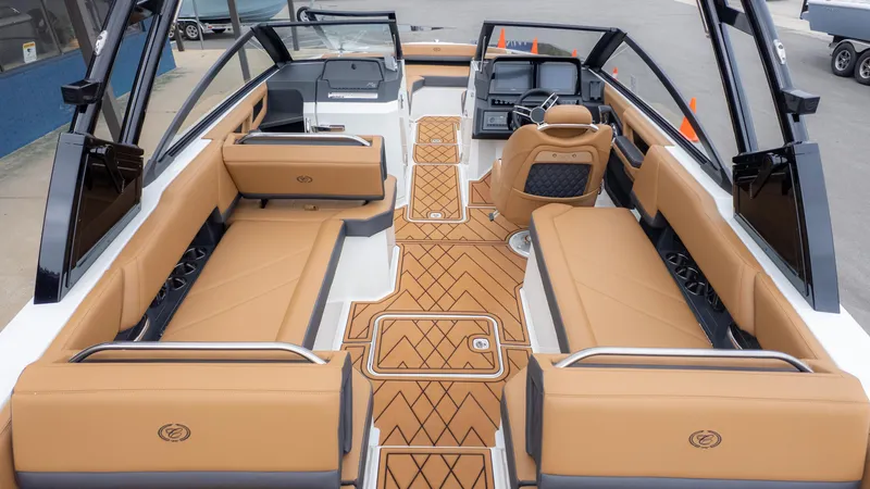 Slide: The Image of 2025 Cobalt R6OB boat interior with tan seating and modern dashboard design. - 11