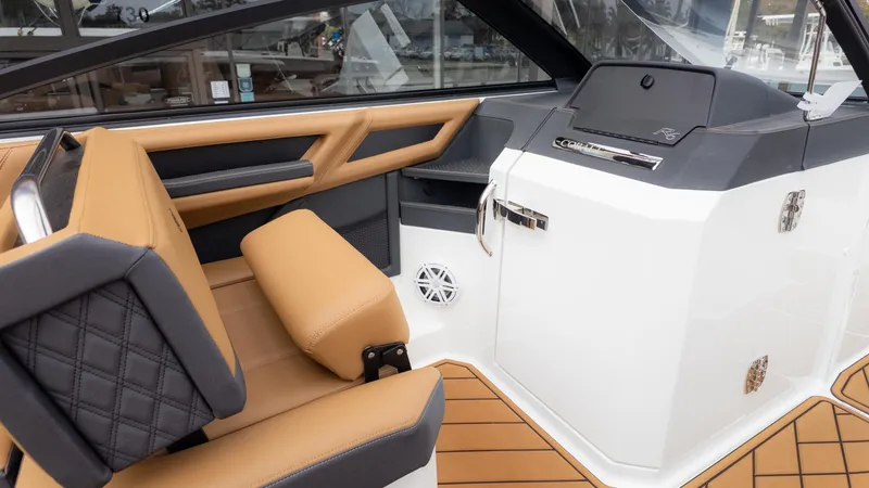 Slide: The Image of 2025 Cobalt R6OB boat interior with tan and black seating, modern dashboard, and sleek design. - 23