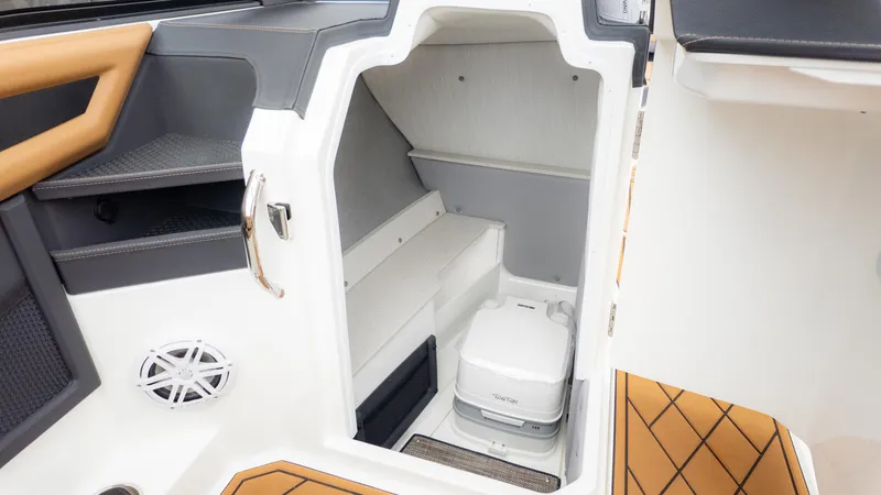 Slide: The Image of 2025 Cobalt R6OB boat interior with compact toilet and storage area. - 24