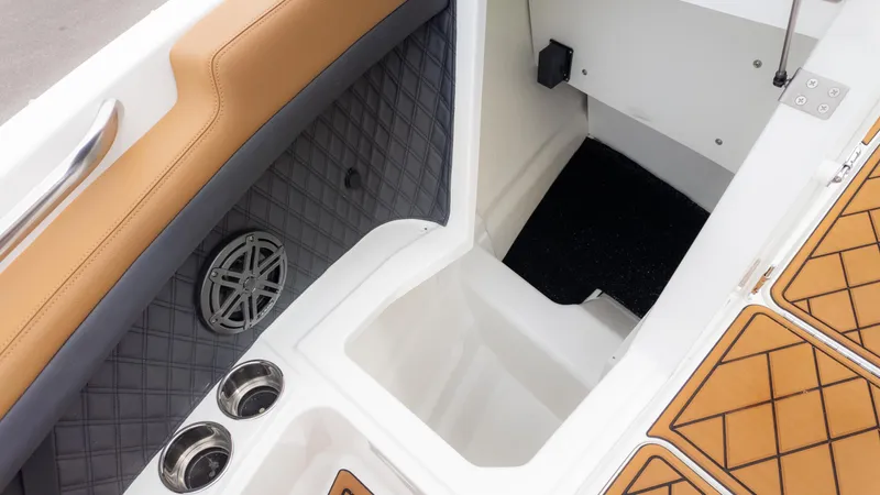 Slide: The Image of 2025 Cobalt R6OB boat interior with tan seating, cup holders, and speaker. - 27
