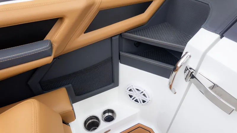 Slide: The Image of Interior of 2025 Cobalt R6OB boat with tan and black seating, cup holders, and speaker. - 35