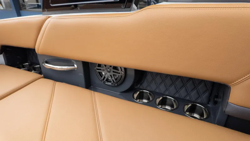 Slide: The Image of 2025 Cobalt R6OB boat interior with tan leather seats, cup holders, and speaker. - 36