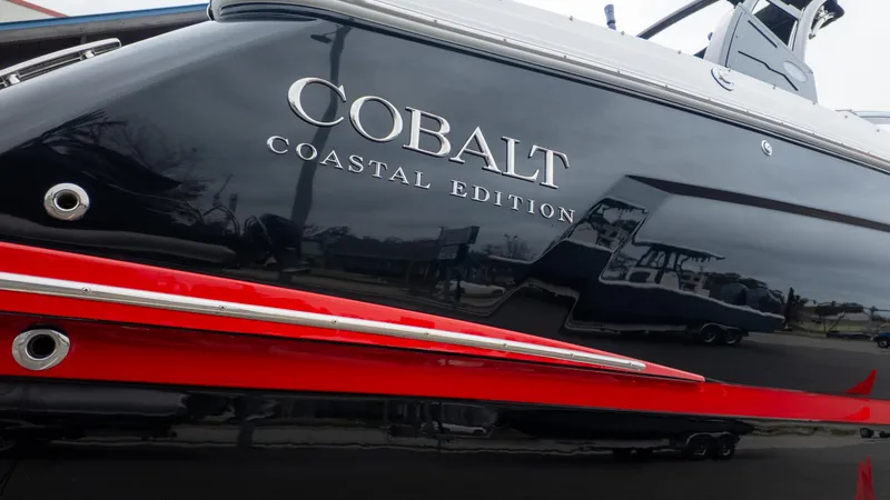 Slide: The Image of 2025 Cobalt R6OB Coastal Edition boat with sleek black and red design. - 6