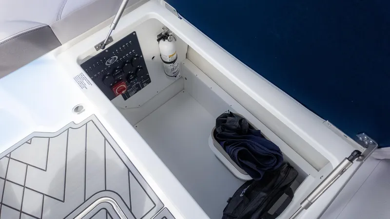 Slide: The Image of Storage compartment in 2025 Cobalt R6OB boat with control panel and fire extinguisher. - 21