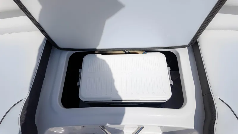 Slide: The Image of 2025 Stingray 172SC boat storage compartment with a white cooler inside. - 12