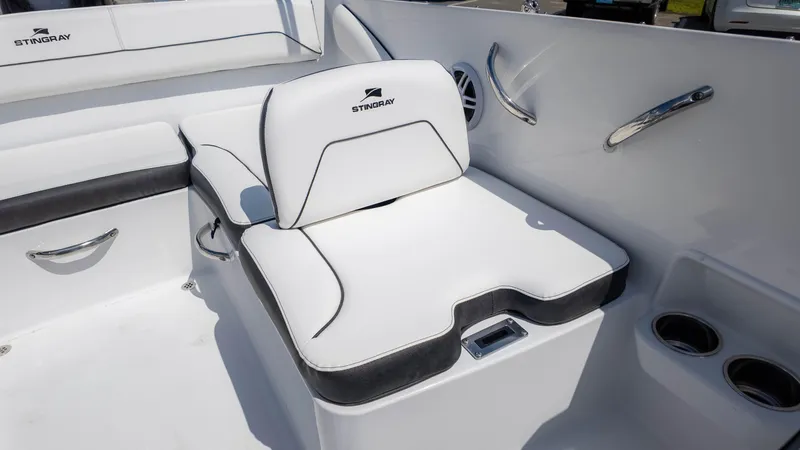 Slide: The Image of 2025 Stingray 172SC boat interior with white cushioned seating and cup holders. - 14
