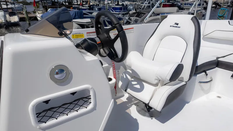 Slide: The Image of 2025 Stingray 172SC boat cockpit with steering wheel and white captain's chair. - 20