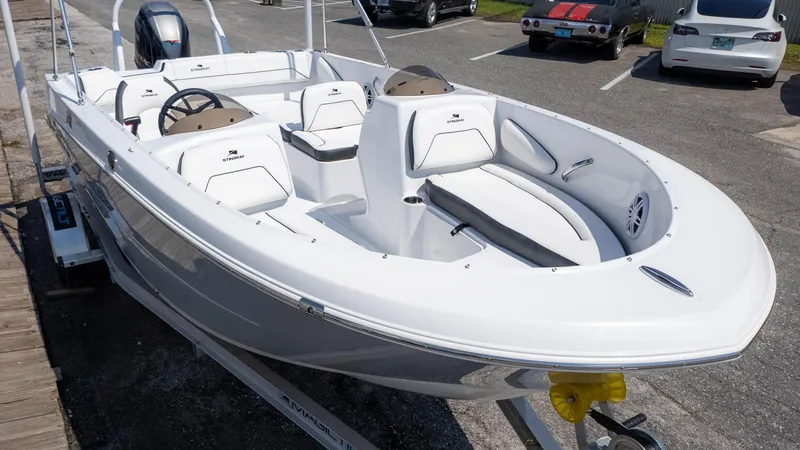 Slide: The Image of 2025 Stingray 172SC boat, white interior, parked on trailer in a lot. - 3