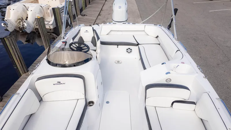 Slide: The Image of 2025 Stingray 192SC boat with spacious seating, docked by the water. - 11