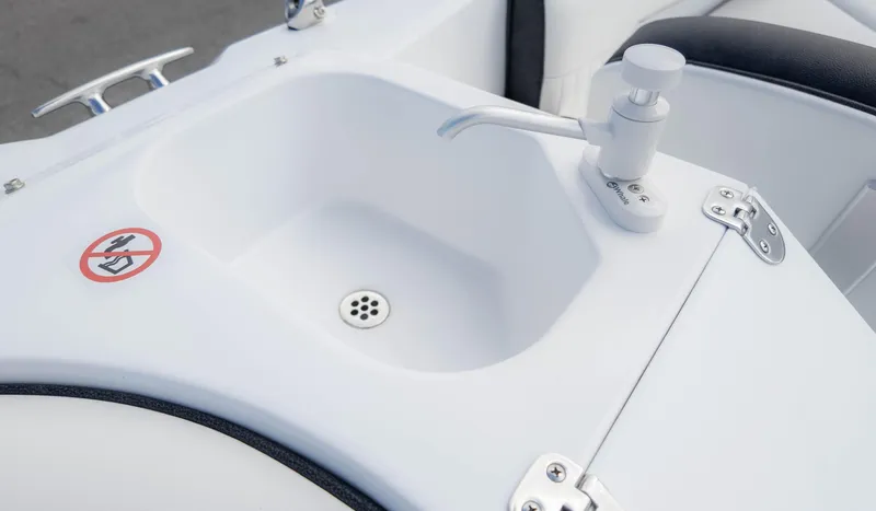 Slide: The Image of Sink with faucet on 2025 Stingray 192SC boat, featuring a no-smoking sign. - 17