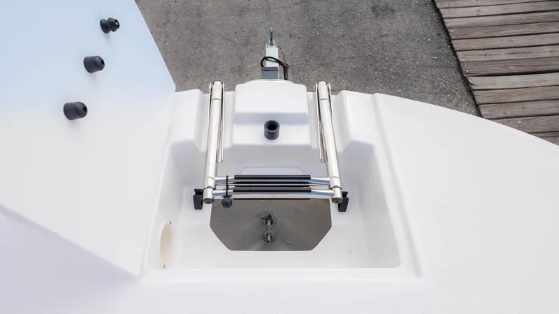 Slide: The Image of 2025 Stingray 192SC boat anchor compartment with stainless steel fittings and dock background. - 20