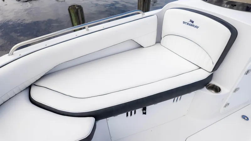 Slide: The Image of 2025 Stingray 192SC boat with white cushioned seating by the water. - 22
