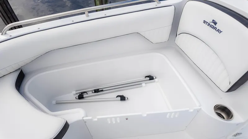 Slide: The Image of 2025 Stingray 192SC boat interior with white seating and storage compartment. - 23