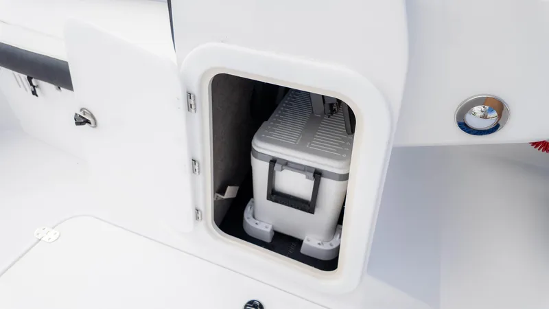 Slide: The Image of 2025 Stingray 192SC boat storage compartment with cooler inside. - 25