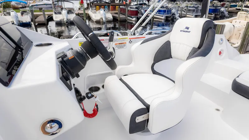 Slide: The Image of 2025 Stingray 192SC boat interior with steering wheel and white captain's chair. - 26