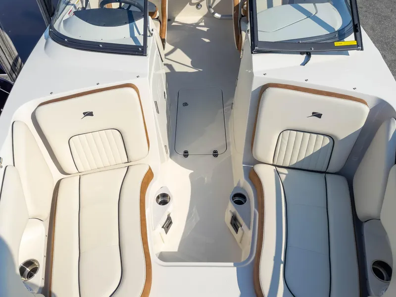 Slide: The Image of 2024 Stingray 211DC boat interior with white cushioned seating and cup holders. - 12