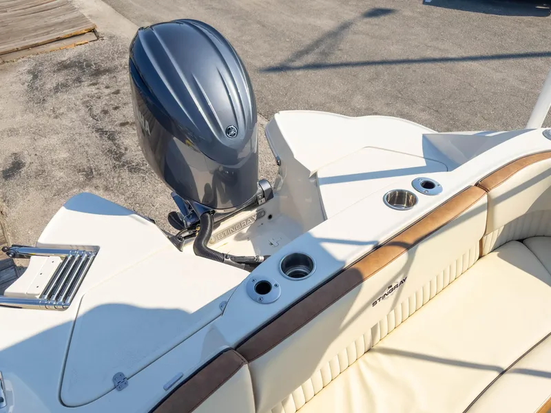 Slide: The Image of 2024 Stingray 211DC boat with Yamaha outboard motor, featuring beige seating and cup holders. - 14