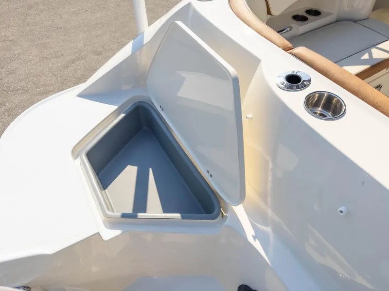 Slide: The Image of 2024 Stingray 211DC boat with open storage compartment and cup holder. - 15