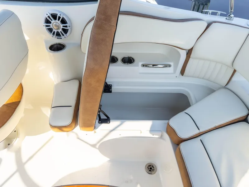 Slide: The Image of 2024 Stingray 211DC boat interior with white and brown seating, cup holders, and speaker. - 17