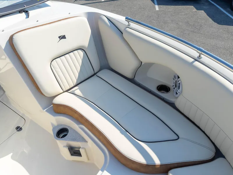 Slide: The Image of 2024 Stingray 211DC boat interior with white cushioned seating and speaker. - 23